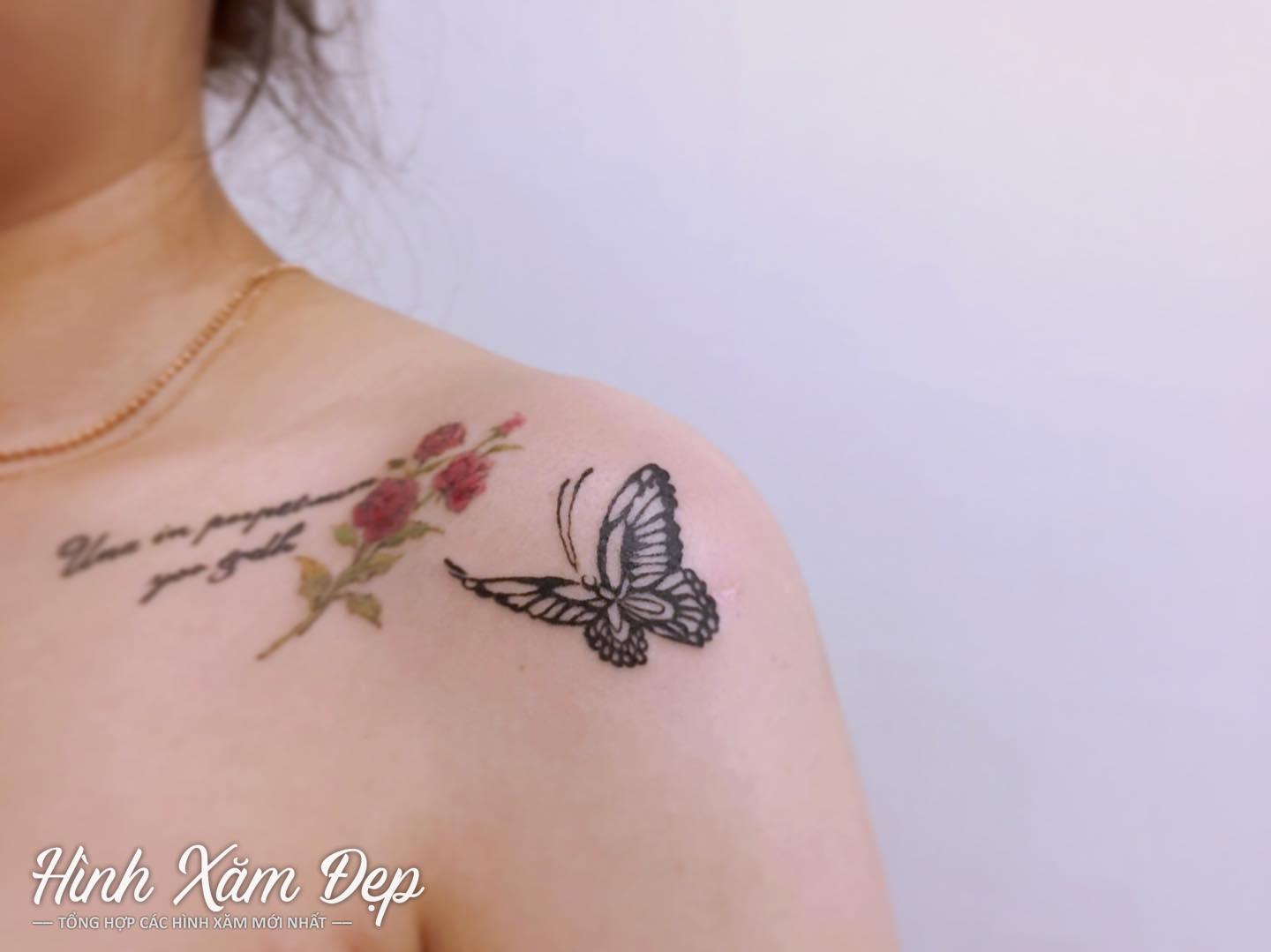 Hình xăm bướm đen kết hợp chữ và hoa ở trước ngực