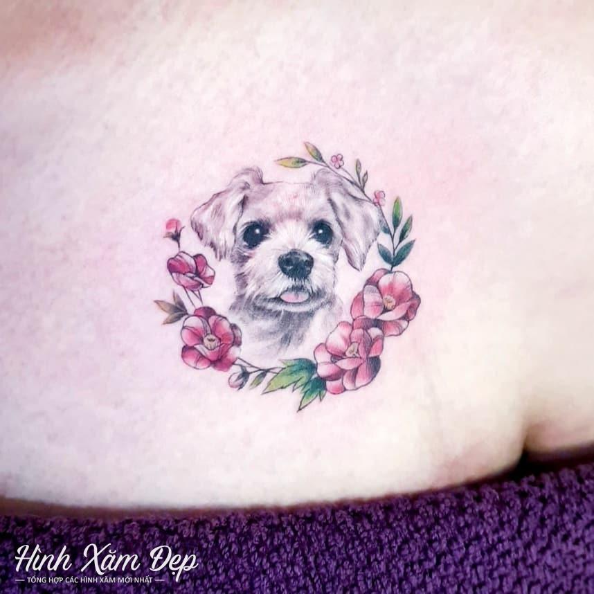 Hình xăm chú cún phối vòng bông hoa trước ngực nữ