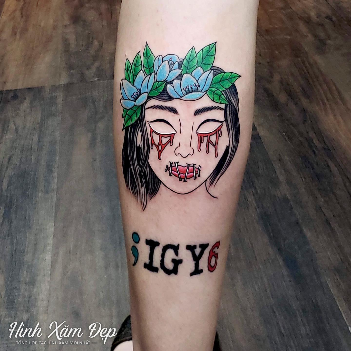 Hình xăm mặt cô gái bắp chân